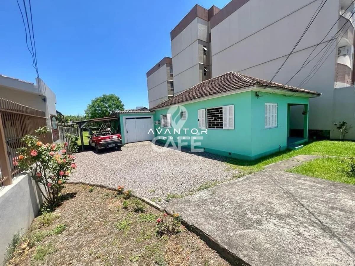 Fachada da casa com garagem e pátio — Terreno à venda em Duque de Caxias, Santa Maria/RS