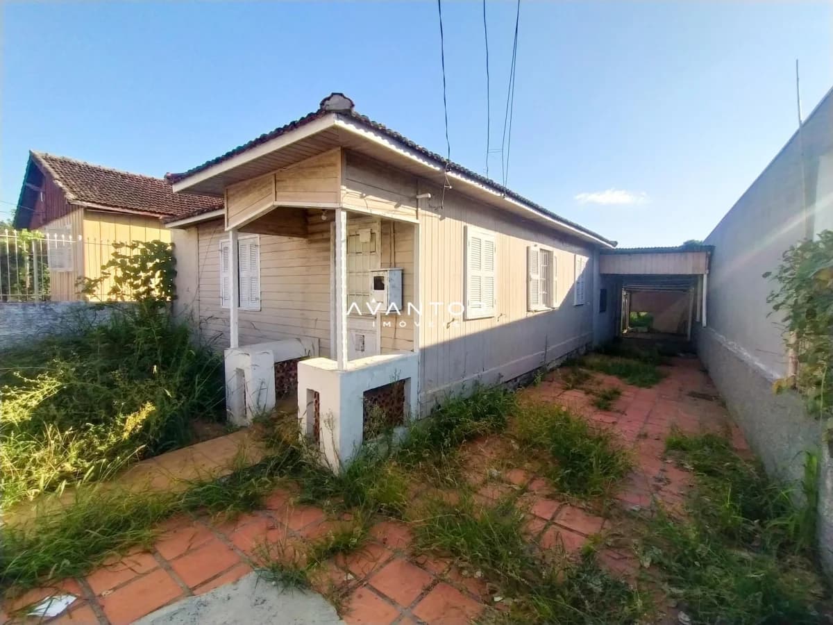 Fachada da casa com pátio lateral — Terreno à venda em Duque de Caxias, Santa Maria/RS