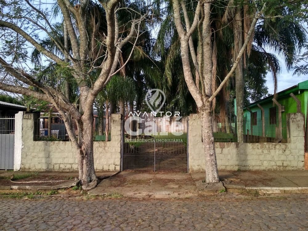 Fachada da casa com portão e árvores — Terreno à venda em Camobi, Santa Maria/RS