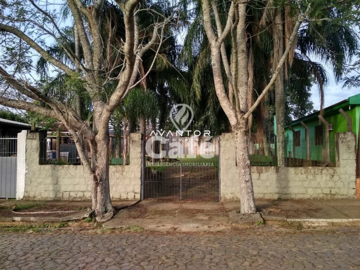 Fachada da casa com portão e árvores — Terreno à venda em Camobi, Santa Maria/RS