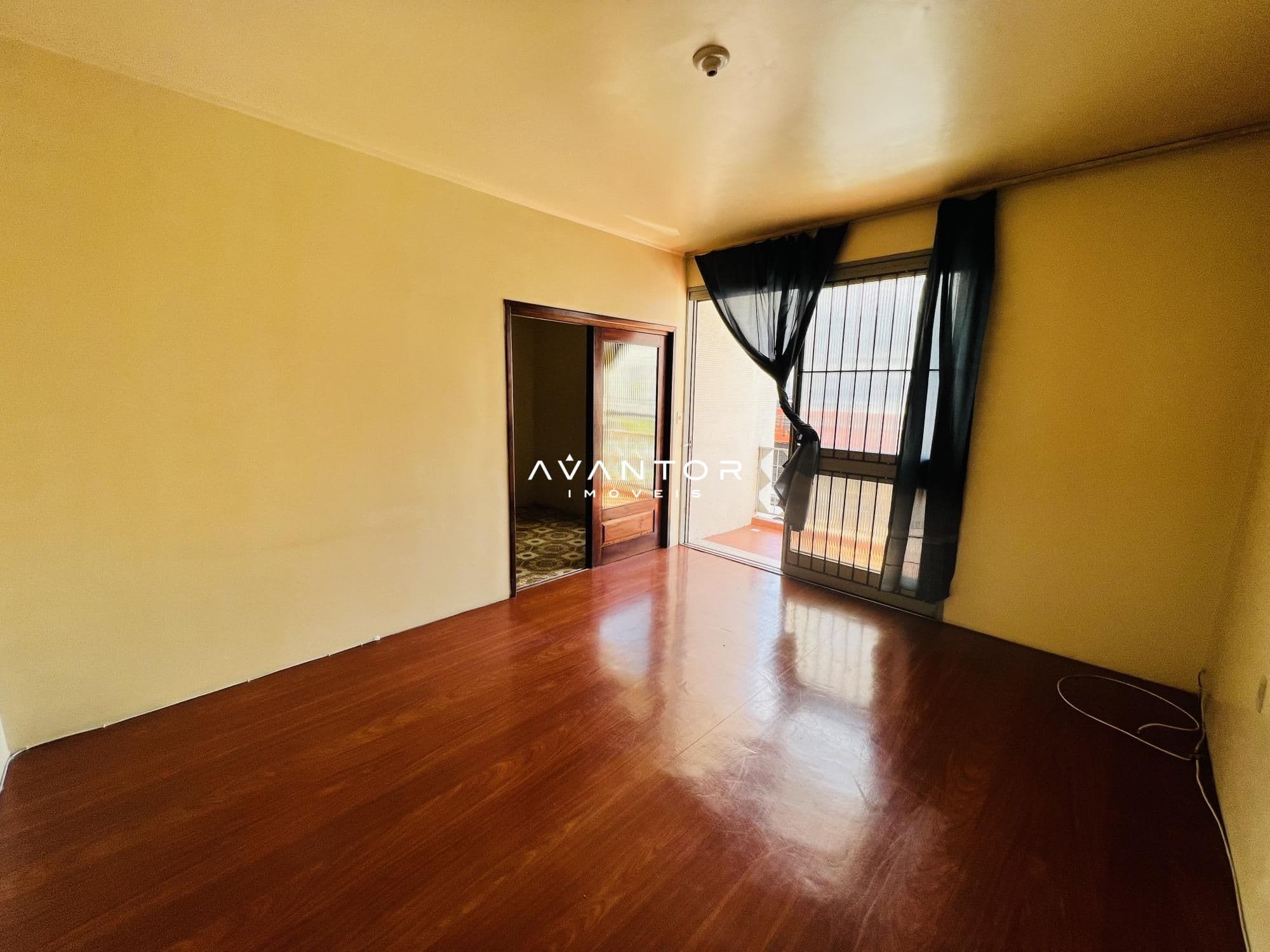 Sala com sacada e piso de madeira — Apartamento com 3 quartos à venda no Edifício Motta, em Centro, Santa Maria/RS