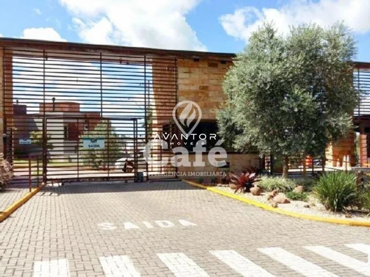 Fachada da casa com garagem e paisagismo — Terreno à venda no Residencial Parque das Oliveiras, em Tomazetti, Santa Maria/RS