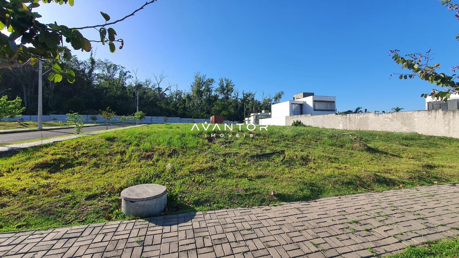 Terreno com área verde e construção ao fundo — Terreno à venda no Cidade Universitária, em Camobi, Santa Maria/RS
