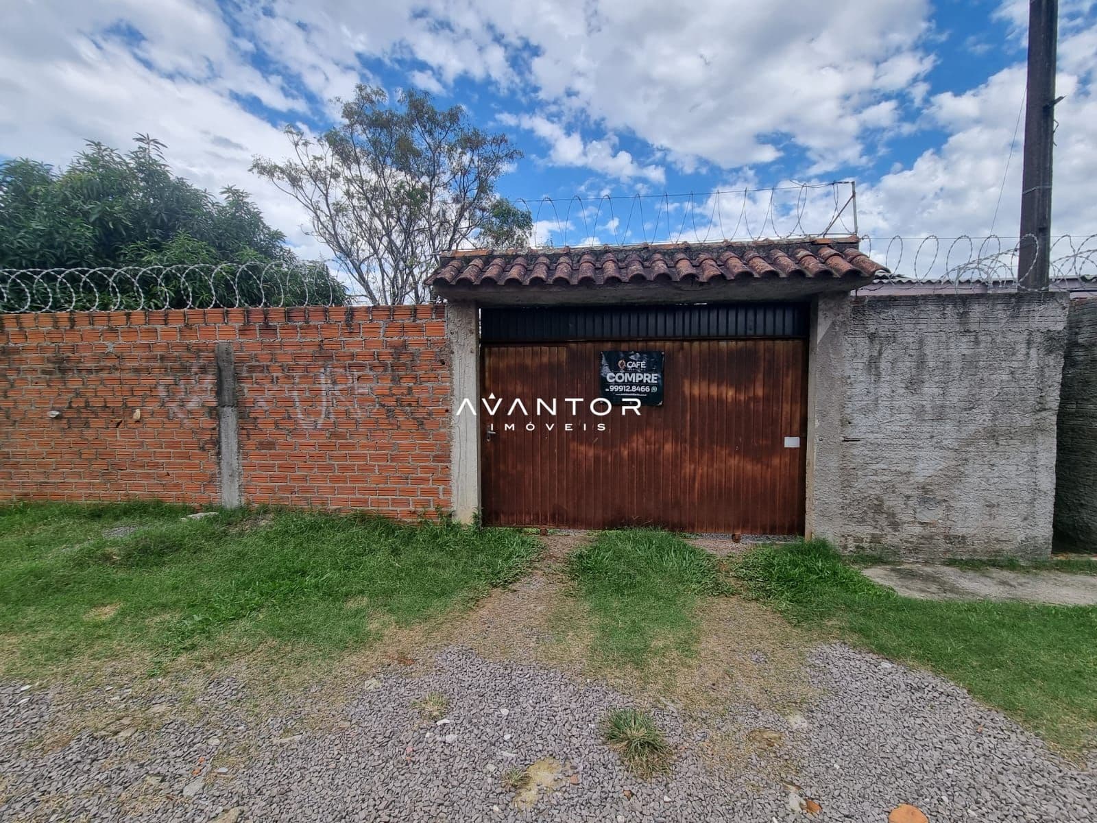Fachada da casa com portão e muro — Terreno à venda em Patronato, Santa Maria/RS