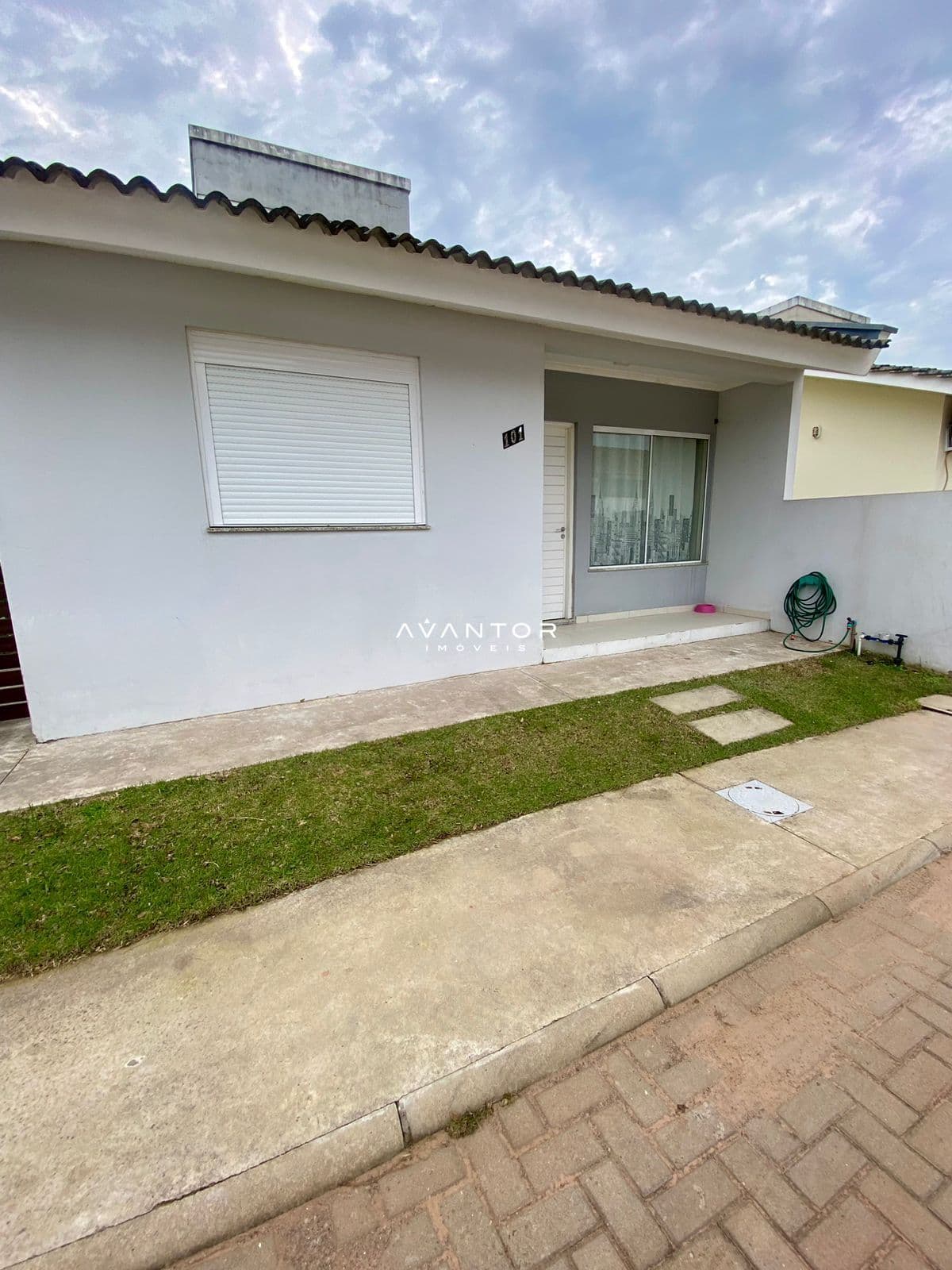 Fachada da casa com pátio e área verde — Casa de Condomínio com 2 quartos à venda em Diácono João Luiz Pozzobon, Santa Maria/RS