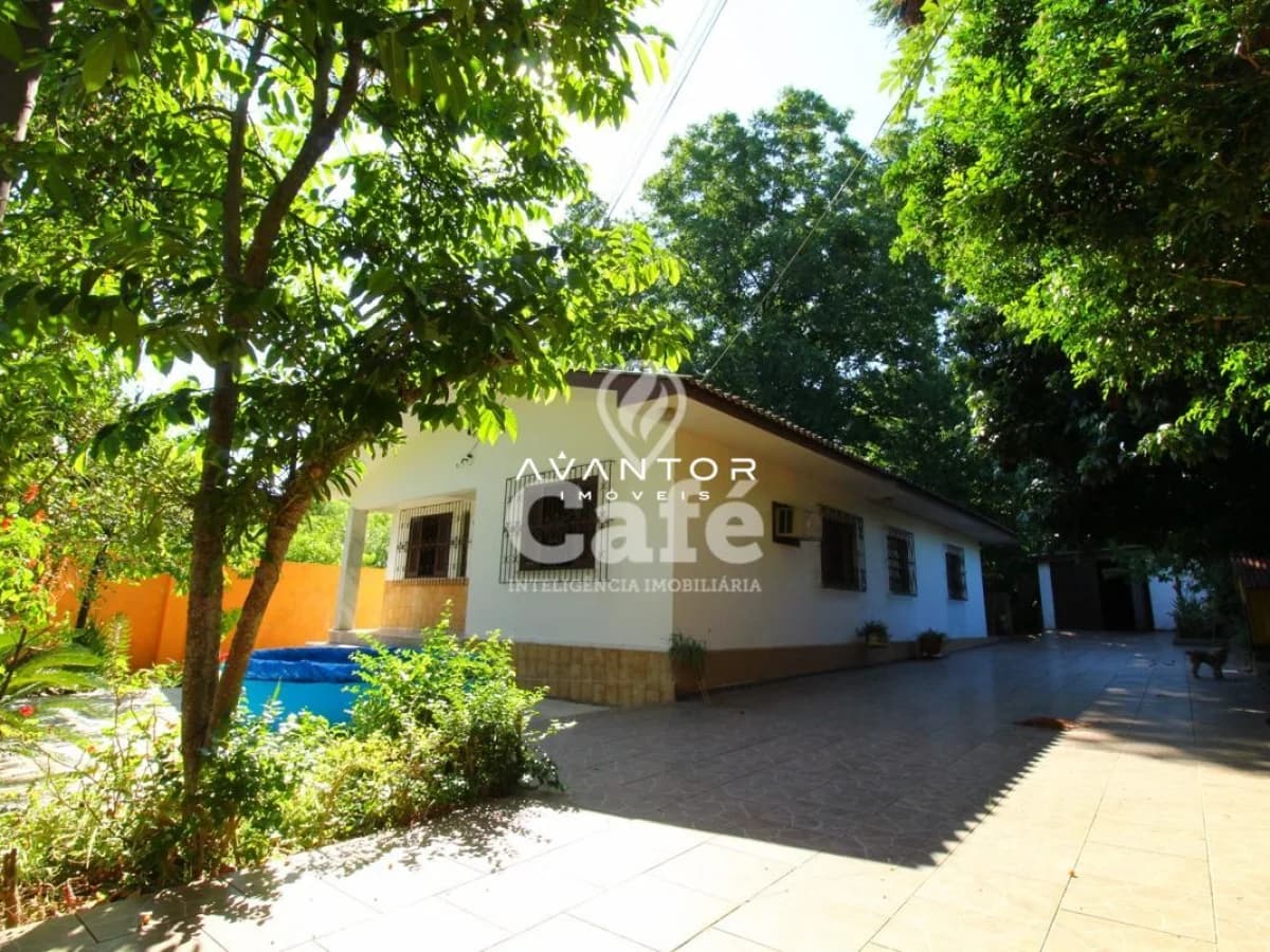 Fachada da casa com área externa arborizada — Casa com 3 quartos à venda em Duque de Caxias, Santa Maria/RS
