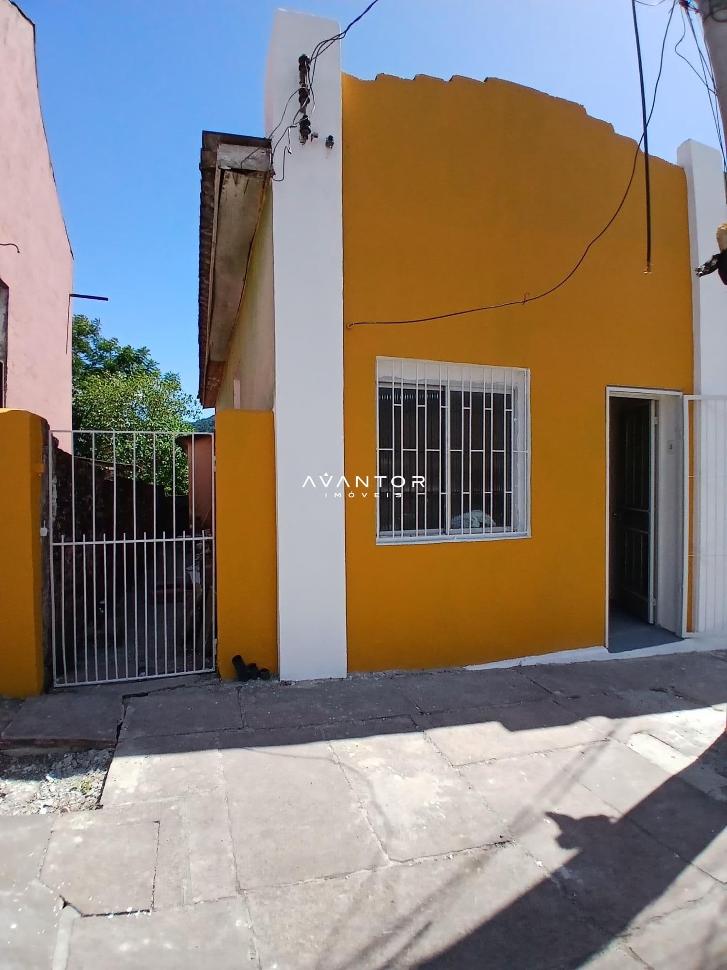 Fachada da casa com parede amarela — Casa com 2 quartos para alugar em Centro, Santa Maria/RS