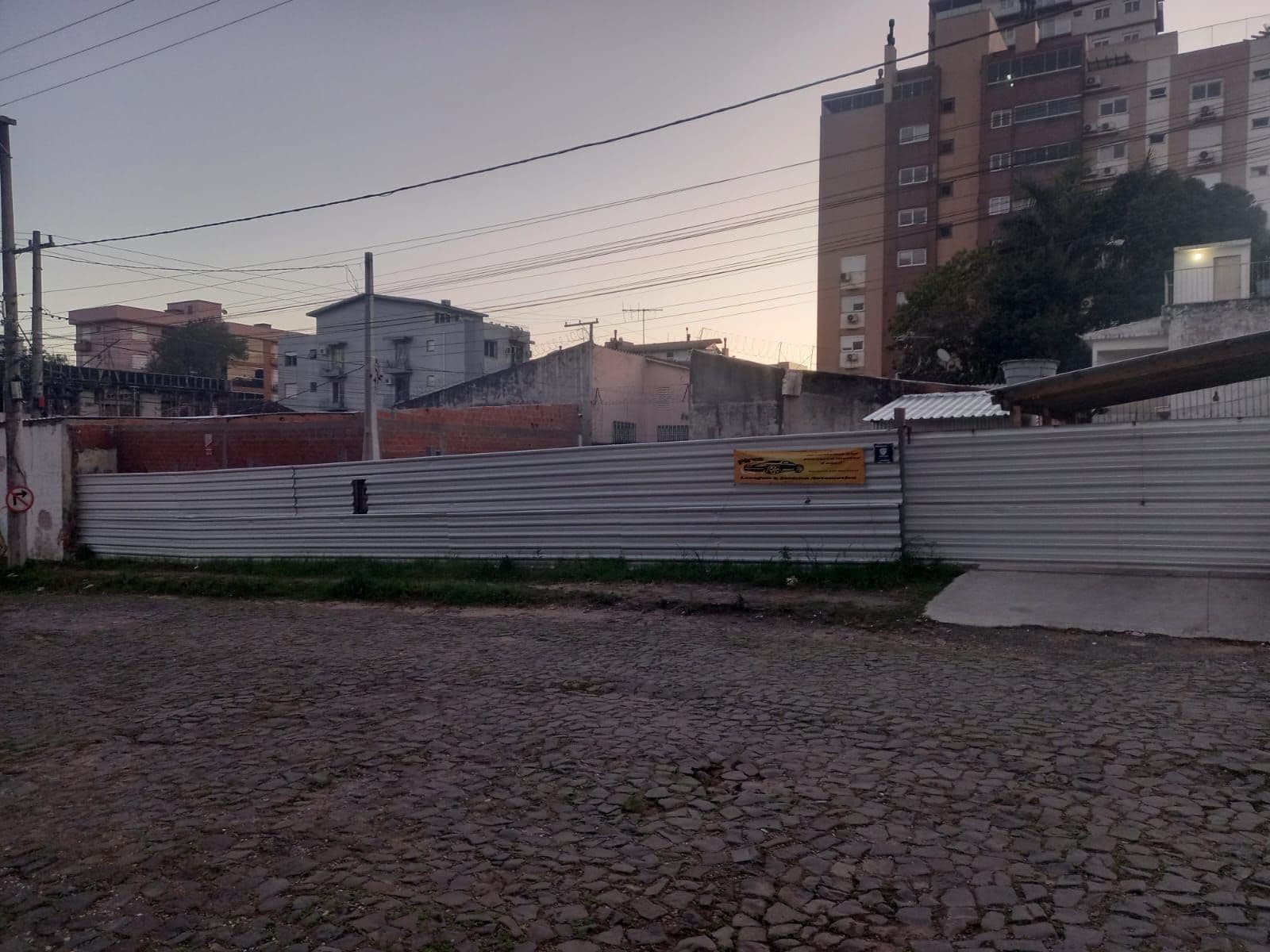 Terreno com cercado de metal e edificações ao fundo — Prédio Comercial com 1 sala à venda em Menino Jesus, Santa Maria/RS