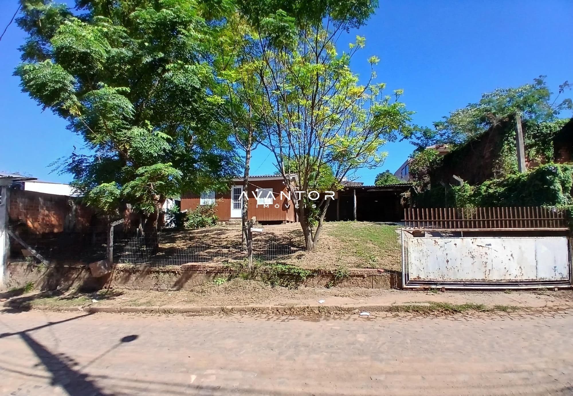 Fachada da casa com terreno arborizado — Casa com 3 quartos à venda em Caturrita, Santa Maria/RS