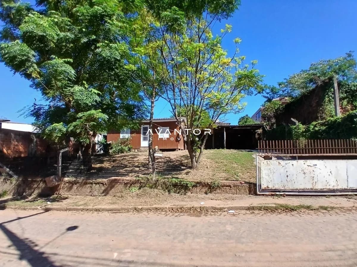 Fachada da casa com terreno arborizado — Casa com 3 quartos à venda em Caturrita, Santa Maria/RS