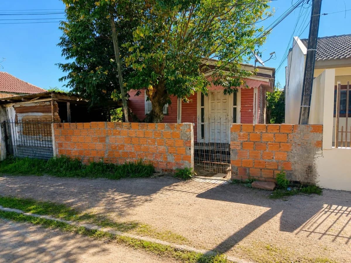 Fachada da casa com muro de tijolos — Terreno à venda em Carolina, Santa Maria/RS