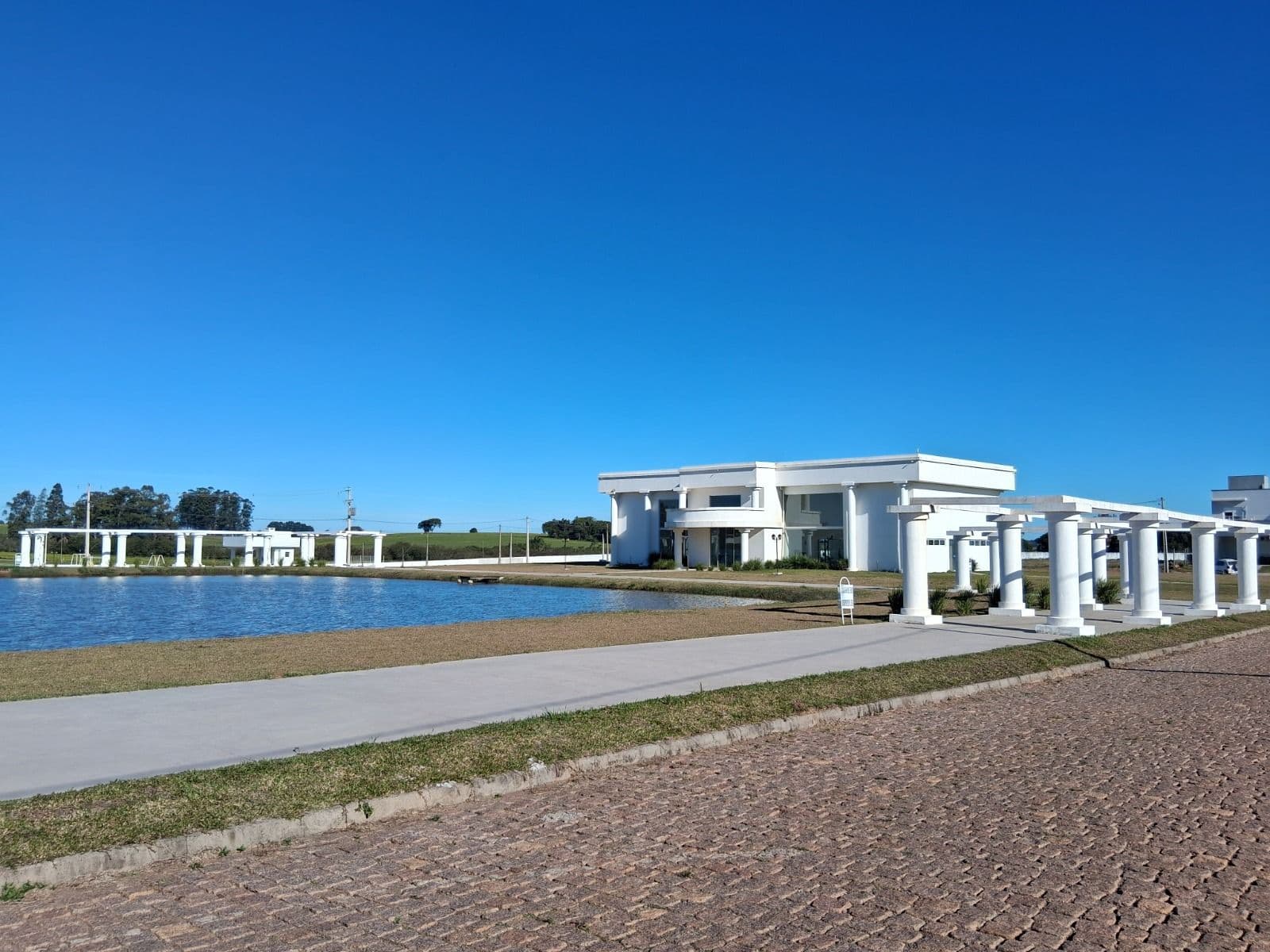Fachada da casa com vista para lago — Terreno à venda no Condomínio Alexandria, em Camobi, Santa Maria/RS