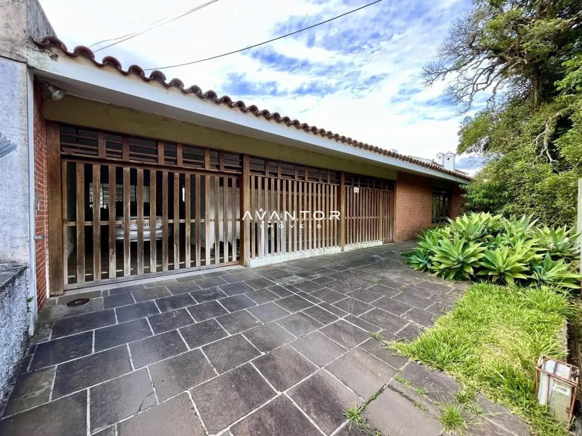 Fachada da casa com garagem e pátio — Casa com 4 quartos à venda em Nossa Senhora de Lourdes, Santa Maria/RS