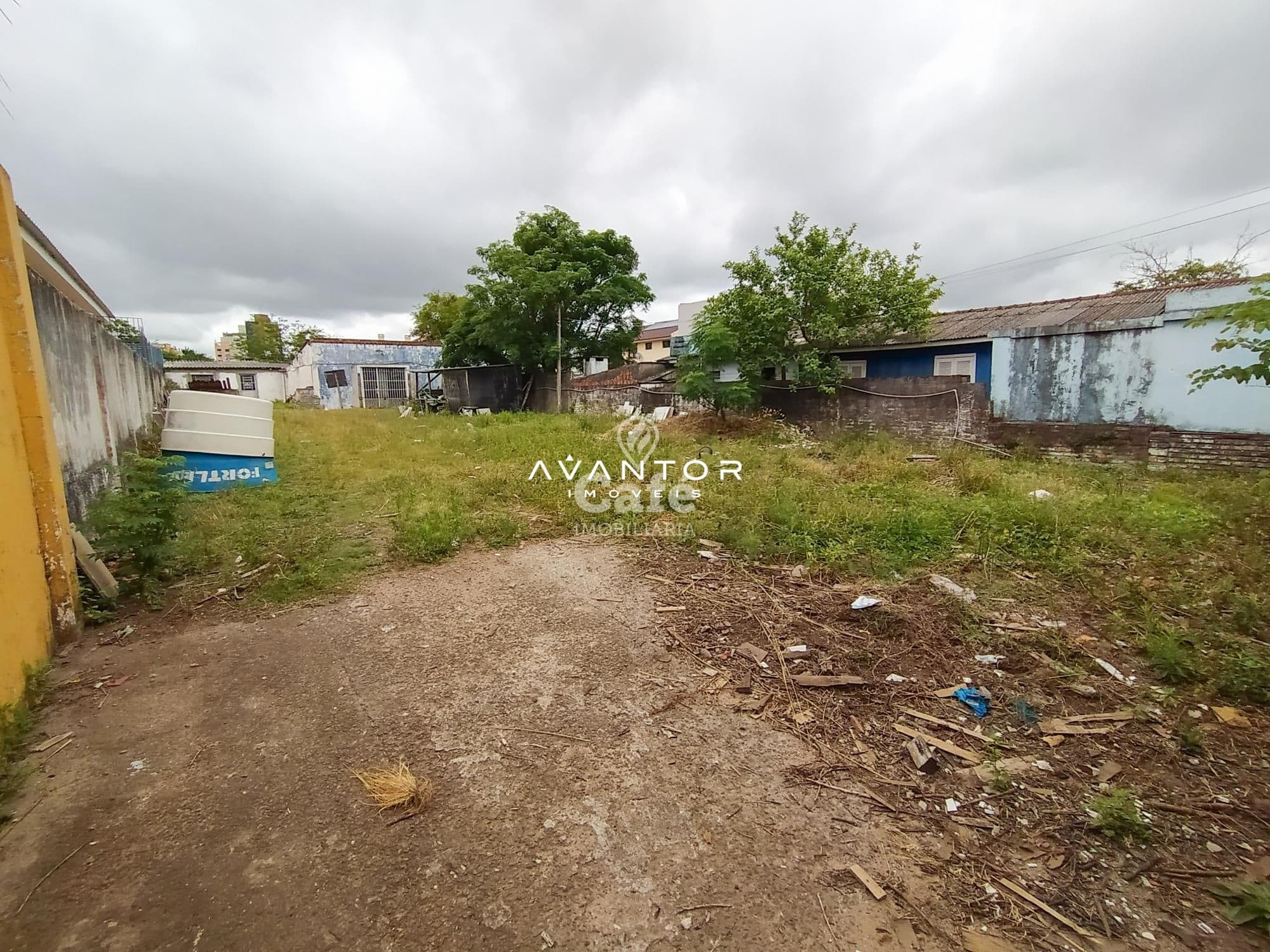 Terreno com vegetação e construções ao fundo — Terreno à venda em Passo D'Areia, Santa Maria/RS