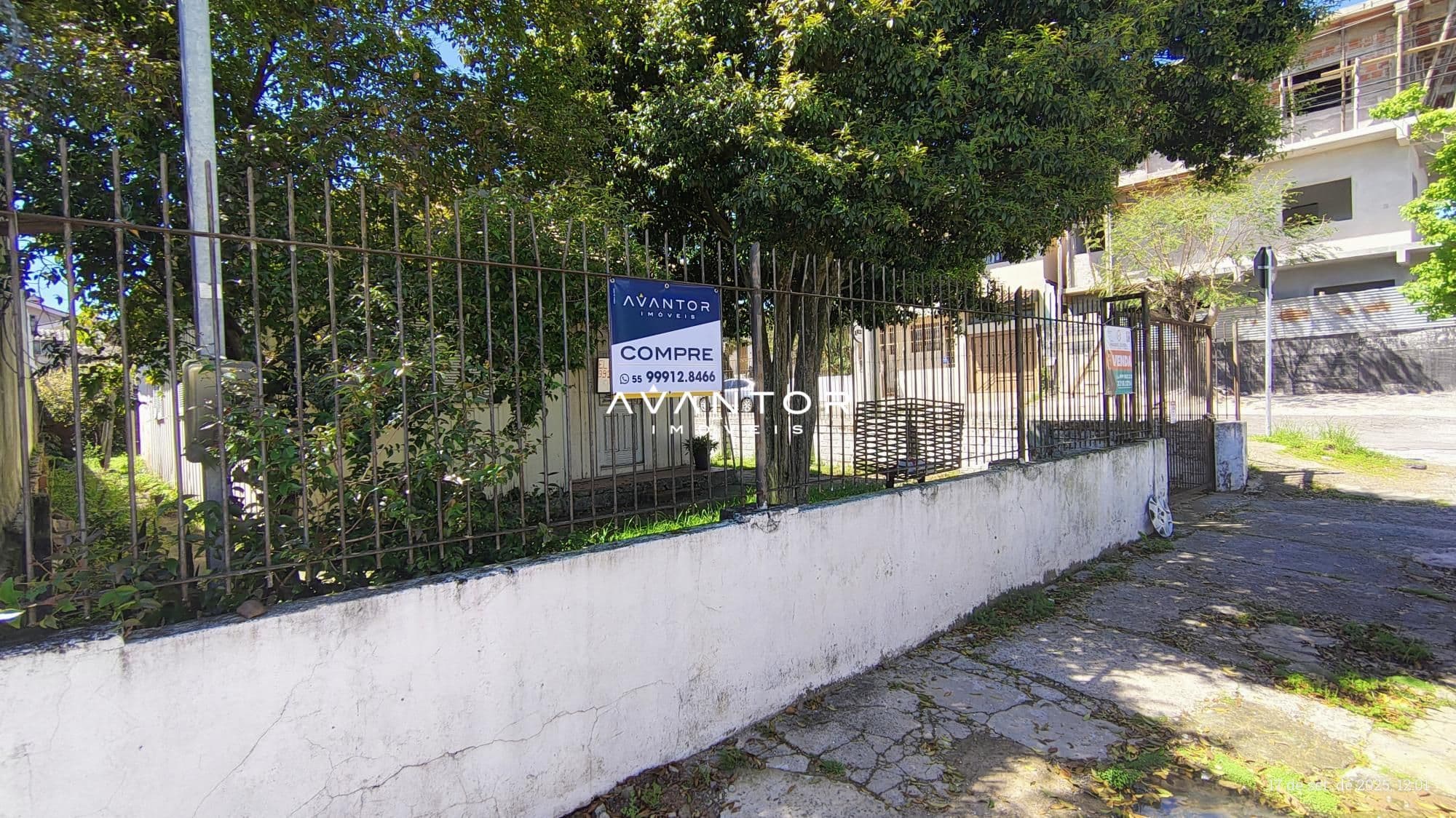 Fachada da casa com portão e muro — Terreno à venda em Duque de Caxias, Santa Maria/RS