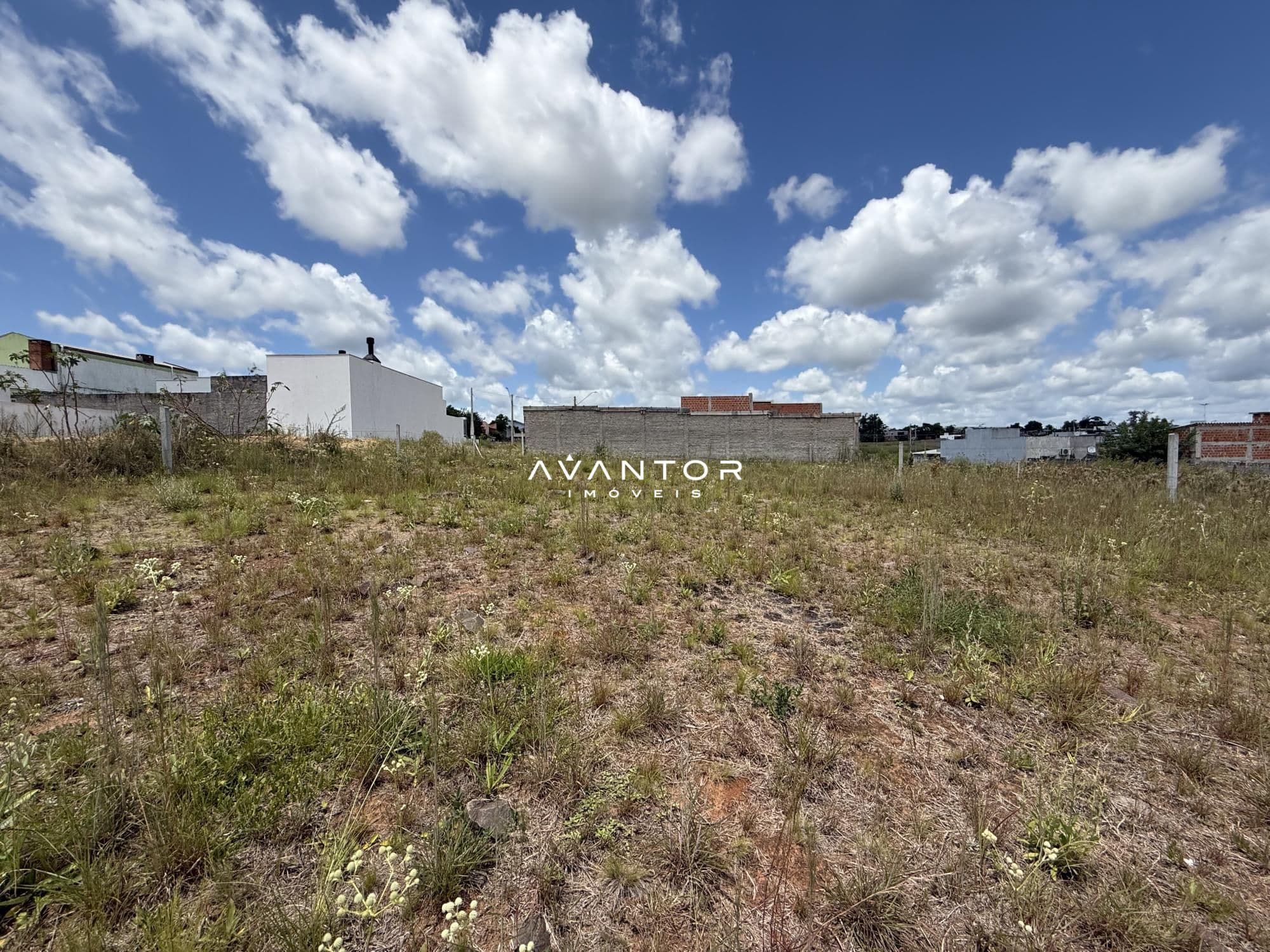 Terreno com construções ao fundo — Terreno à venda em Pinheiro Machado, Santa Maria/RS