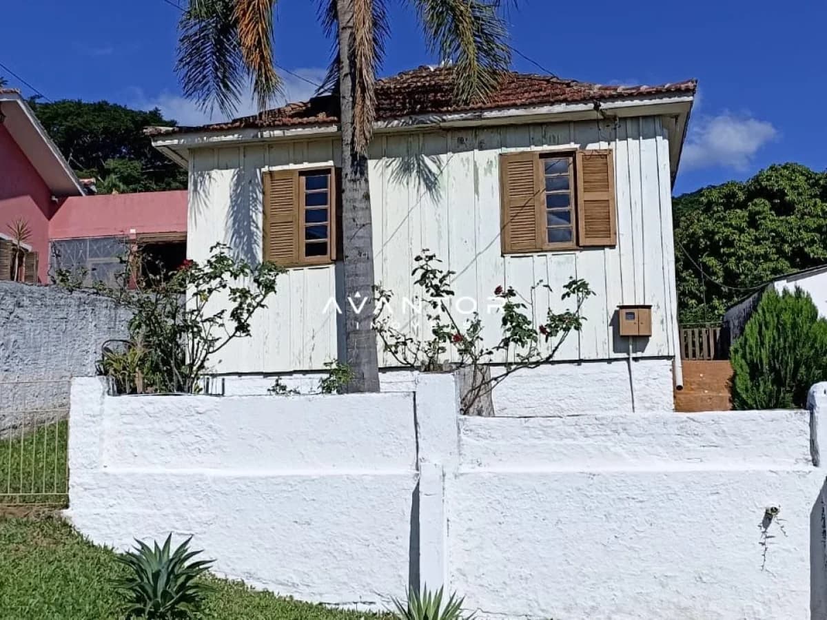 Fachada da casa com palmeira — Terreno à venda em Nossa Senhora do Perpétuo Socorro, Santa Maria/RS