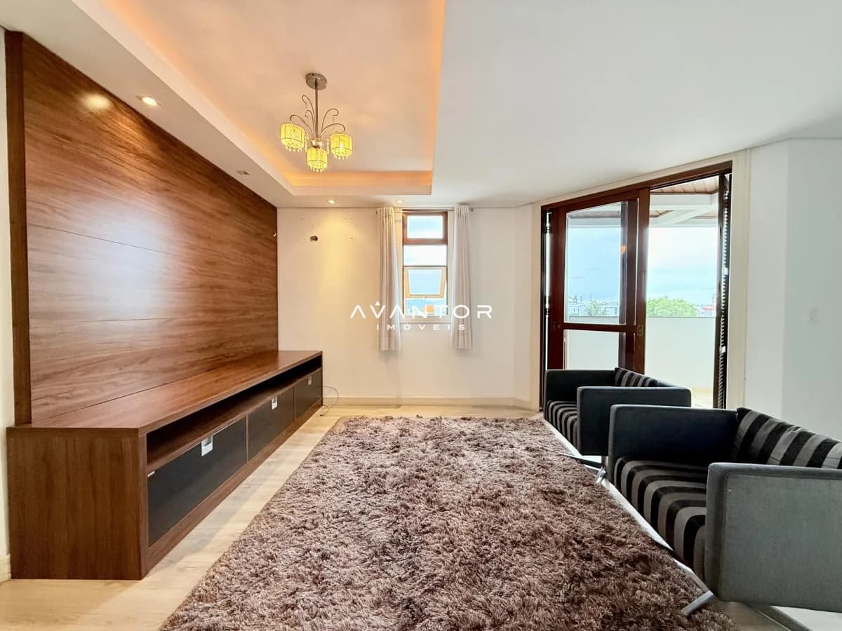 Sala de estar com sacada e painel de madeira — Cobertura com 4 quartos à venda no Edifício Veneza, em Camobi, Santa Maria/RS