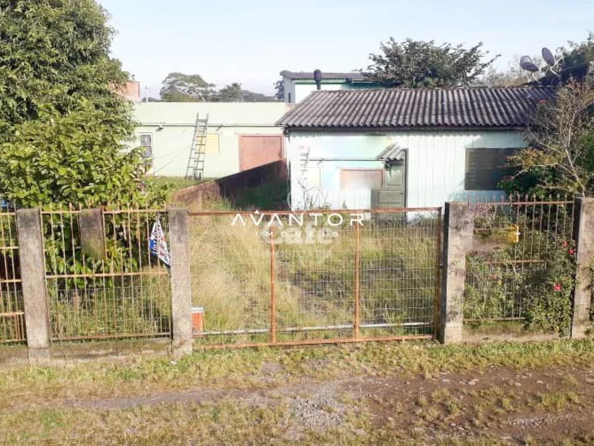 Fachada da casa com portão e pátio — Terreno à venda em Uglione, Santa Maria/RS