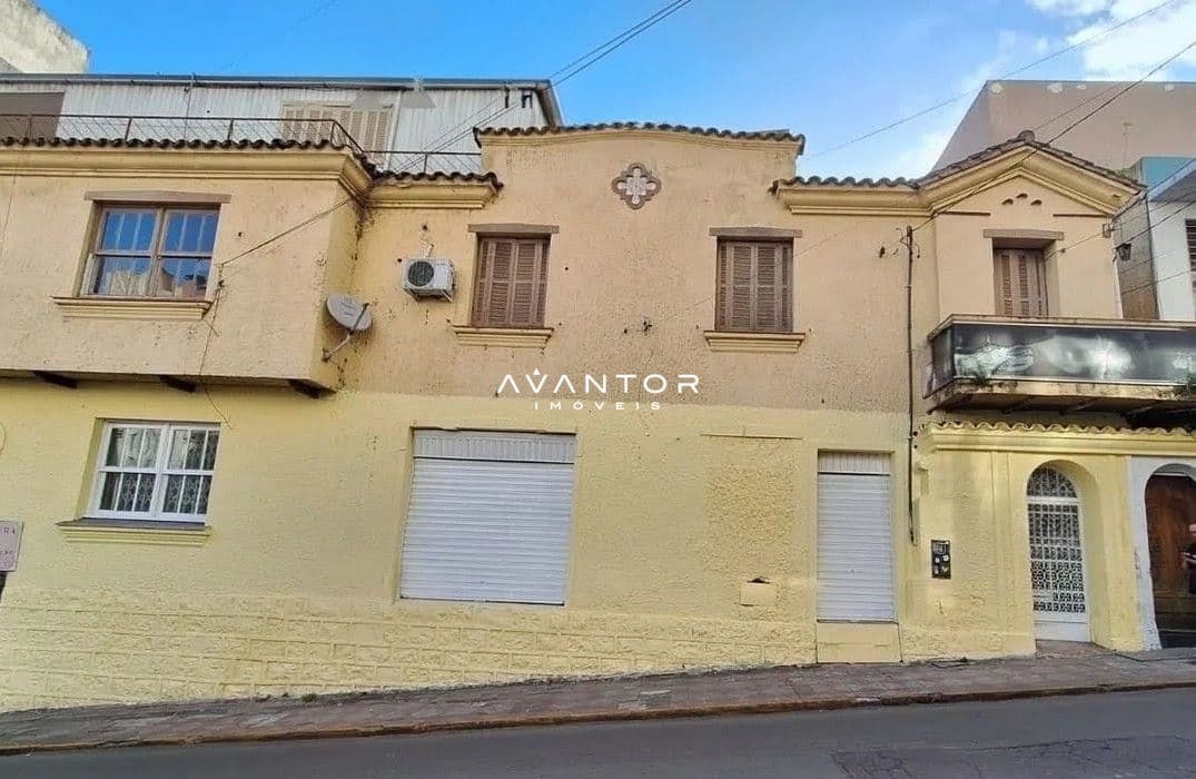 Fachada da casa com acabamento em tons amarelos — Loja com 4 salas para alugar em Centro, Santa Maria/RS