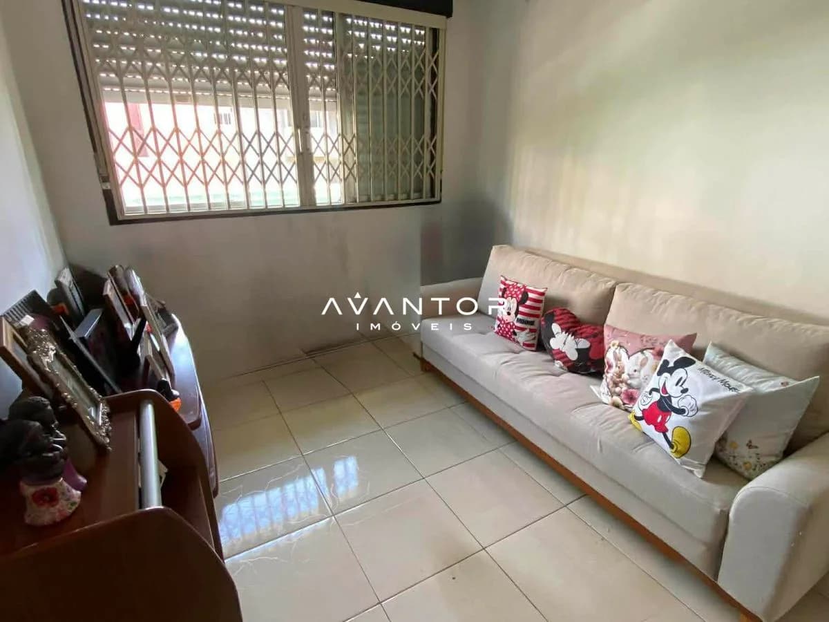 Sala de estar com sofá e janela com grades — Edifício Degas, Centro, Santa Maria/RS