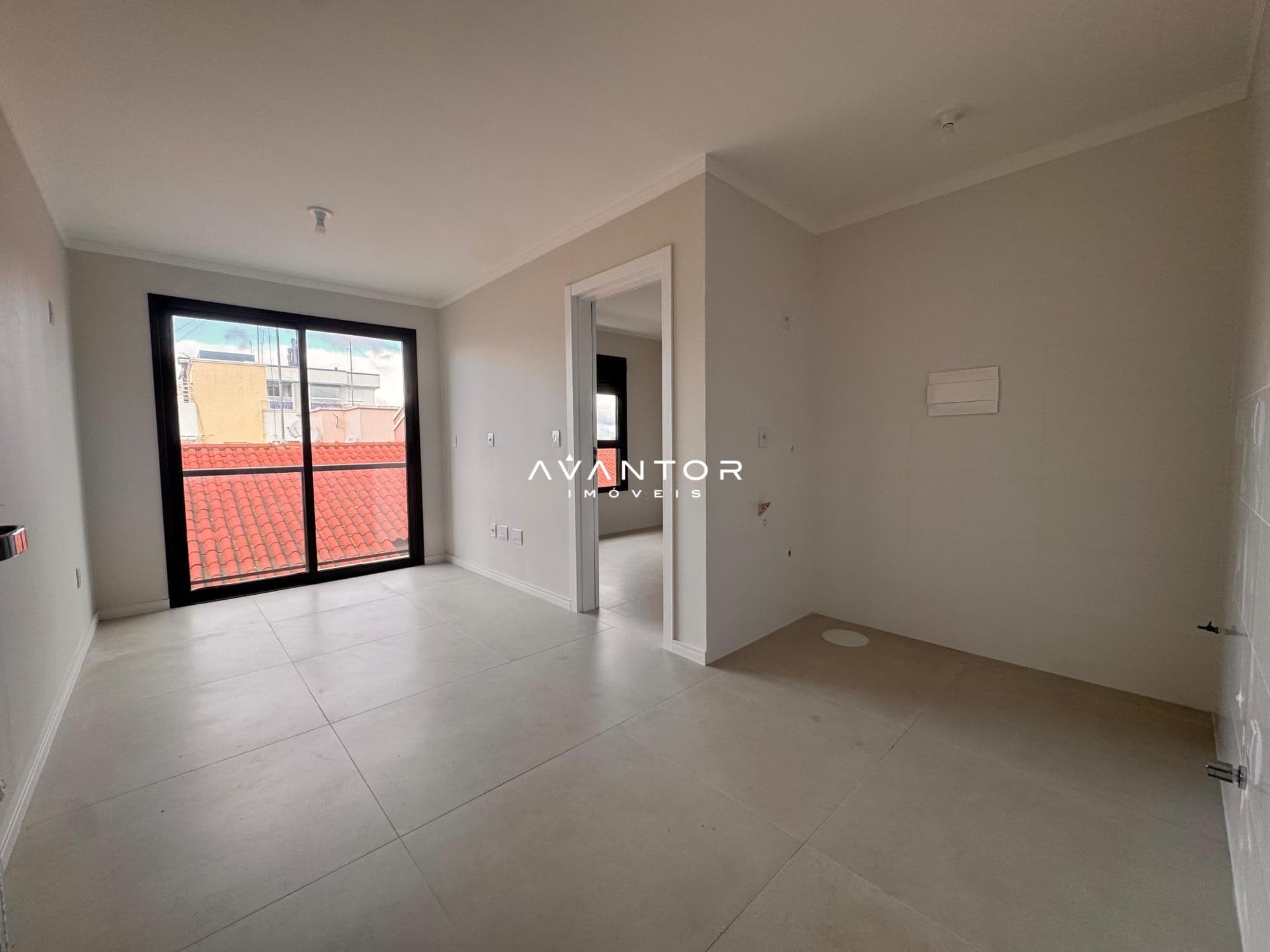 Sala de estar com sacada e vista para telhado — Apartamento com 1 quarto à venda em Camobi, Santa Maria/RS