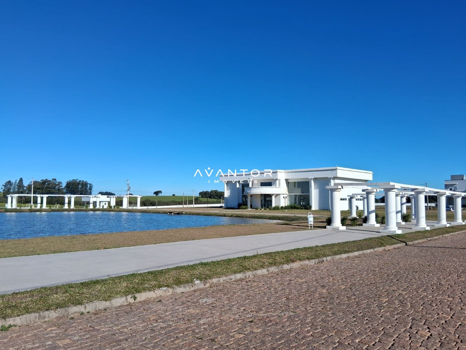 Fachada do edifício com vista para a lagoa — Terreno à venda no Condomínio Alexandria, em Camobi, Santa Maria/RS