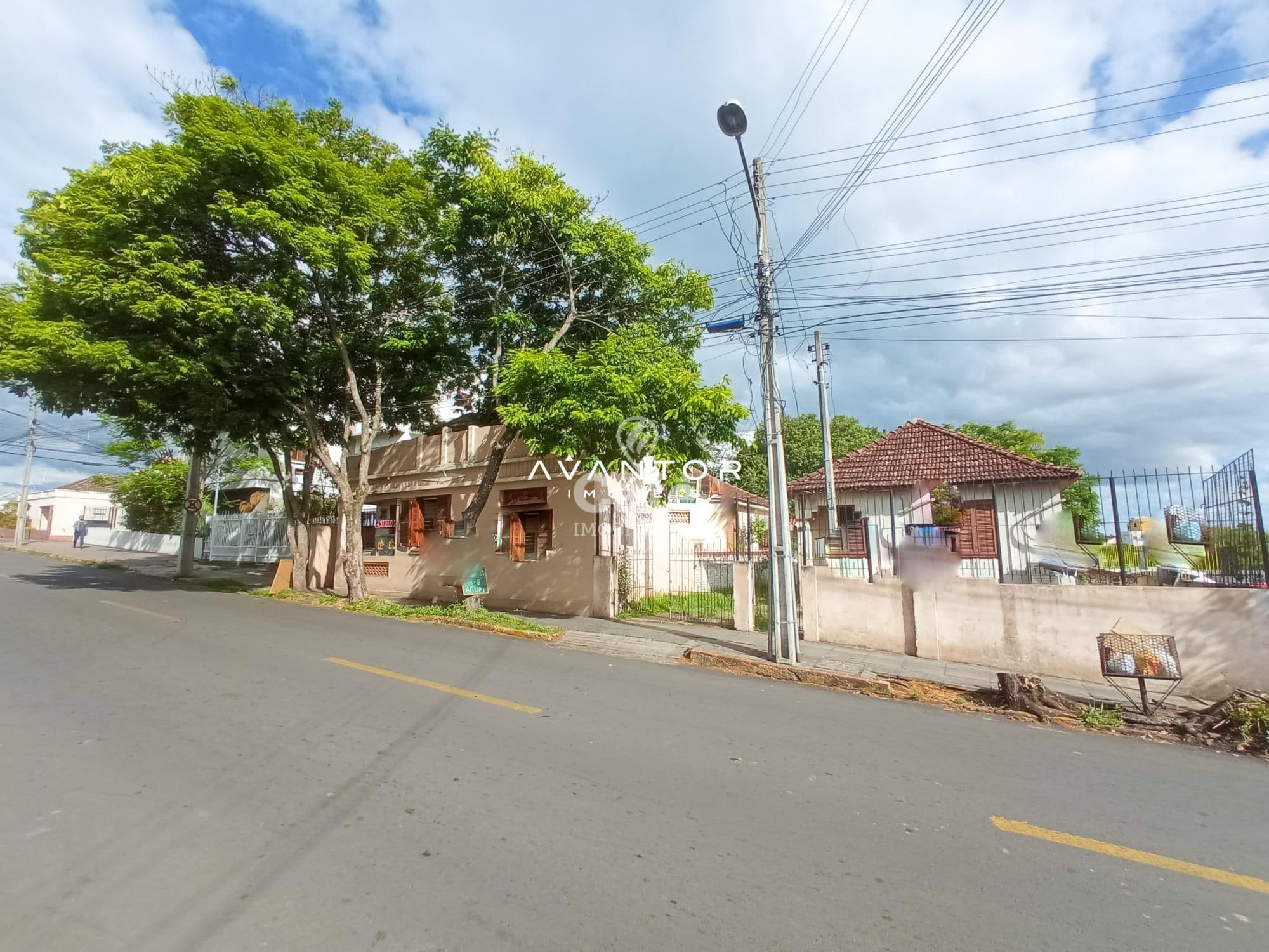 Fachada da casa com terreno e árvore — Terreno à venda em Duque de Caxias, Santa Maria/RS