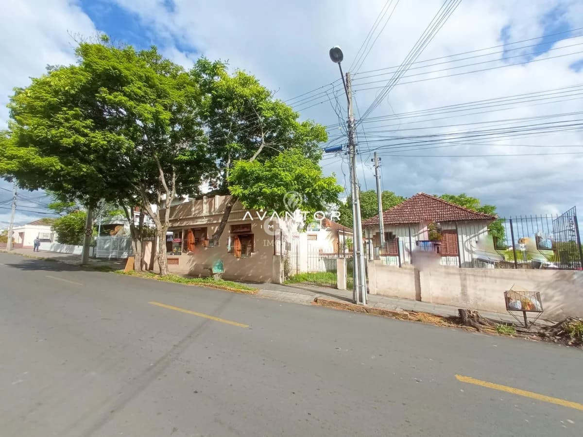 Fachada da casa com terreno e árvore — Terreno à venda em Duque de Caxias, Santa Maria/RS