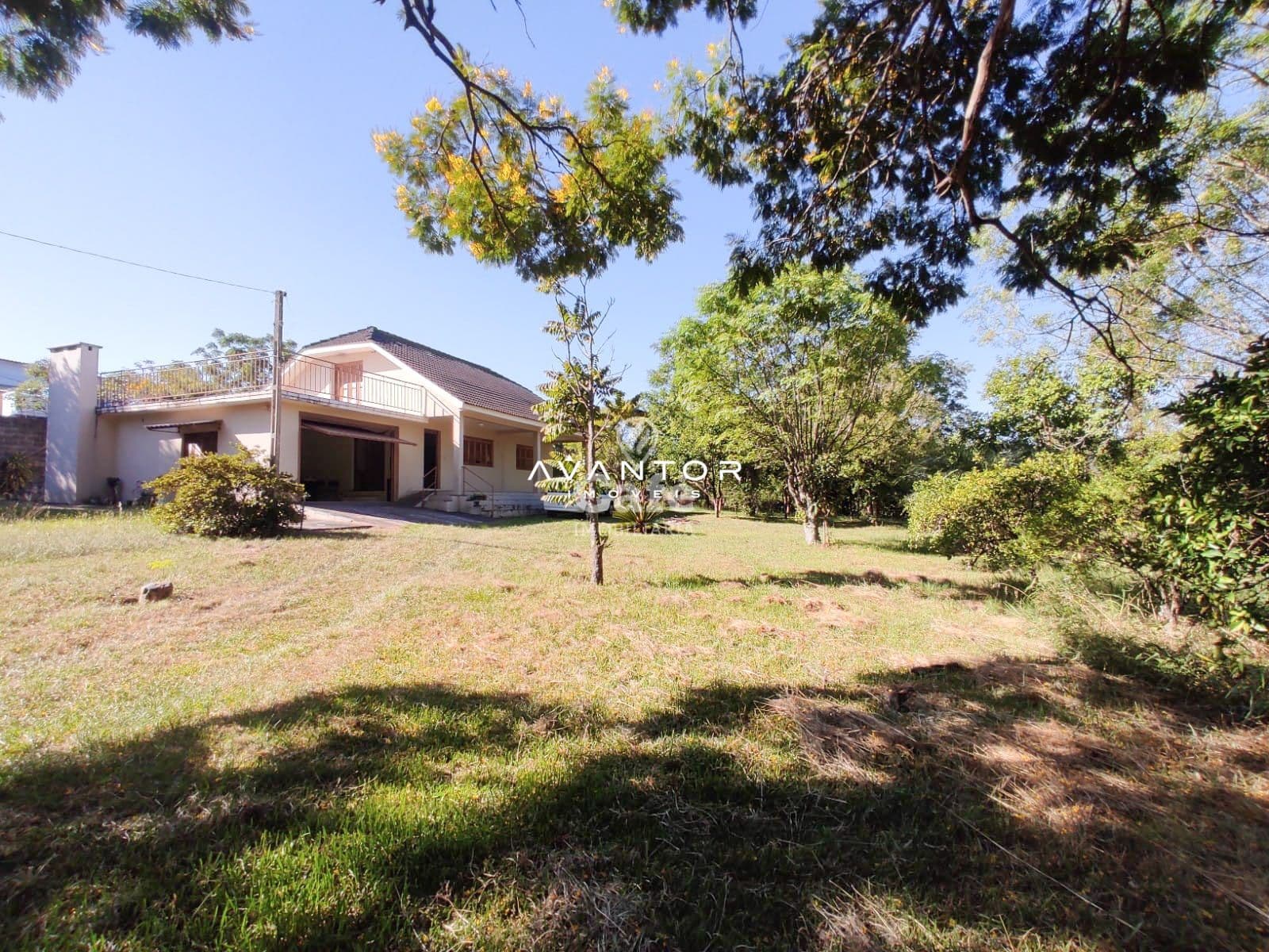 Fachada da casa com terreno e árvores — Terreno à venda em Pé de Plátano, Santa Maria/RS