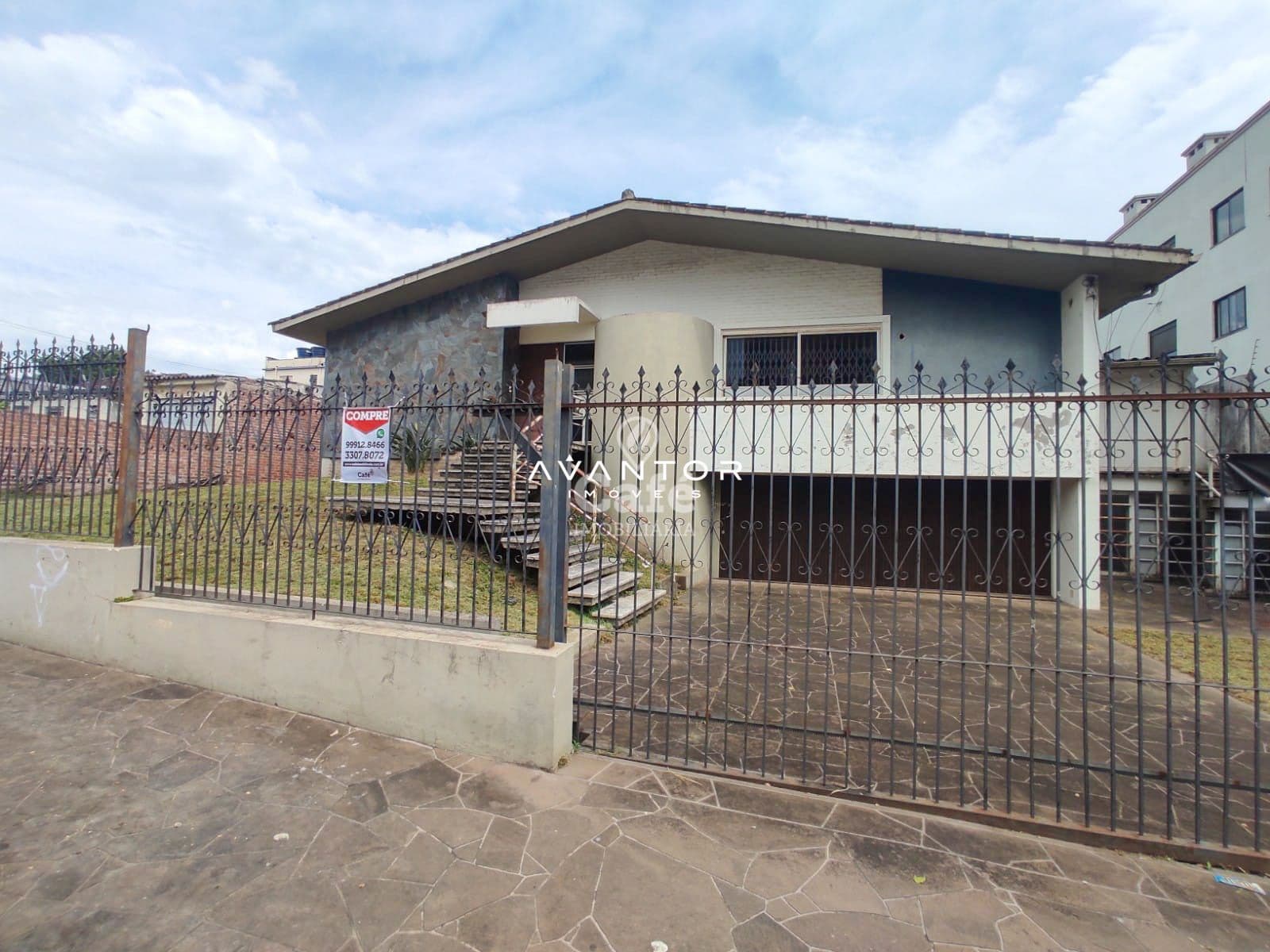 Fachada da casa com portão e sacada — Terreno à venda em Nossa Senhora do Rosário, Santa Maria/RS