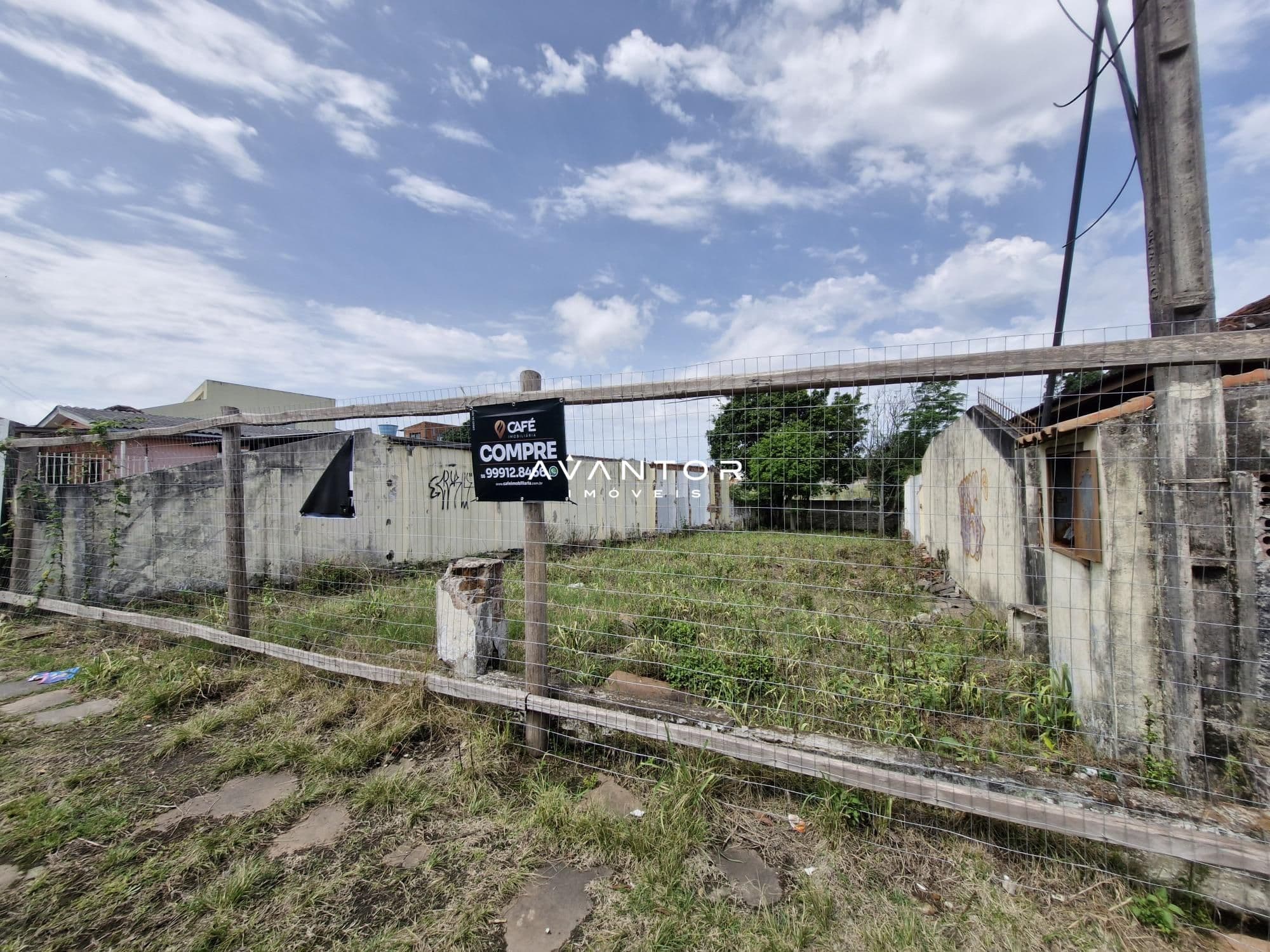 Terreno com construções e placa de venda — Terreno à venda em Nossa Senhora do Perpétuo Socorro, Santa Maria/RS
