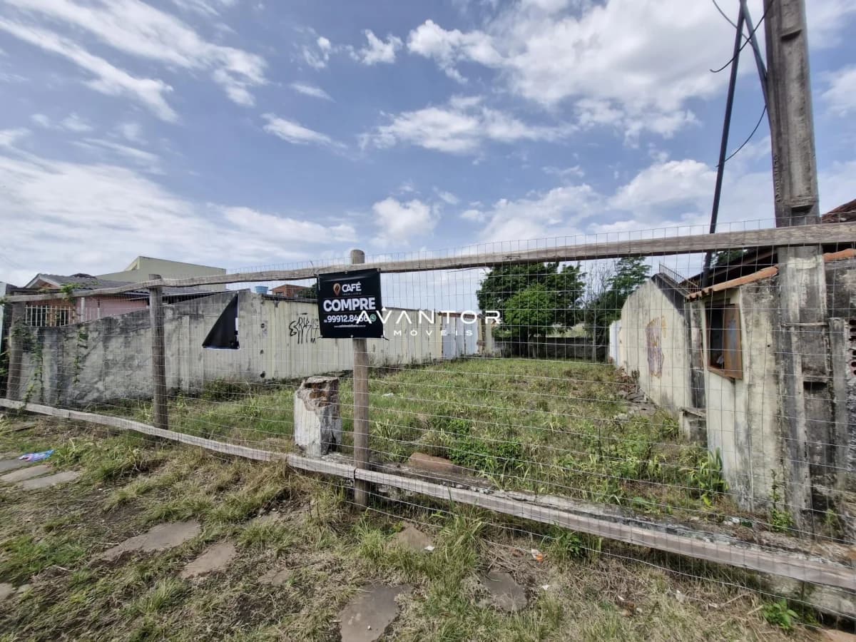 Terreno com construções e placa de venda — Terreno à venda em Nossa Senhora do Perpétuo Socorro, Santa Maria/RS