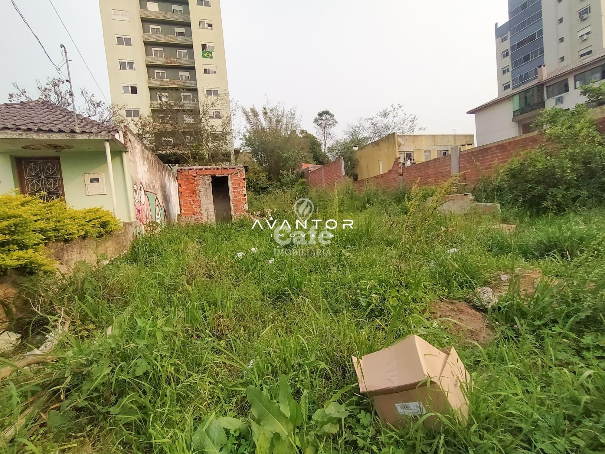 Terreno com construções e vegetação — Terreno à venda em Centro, Santa Maria/RS