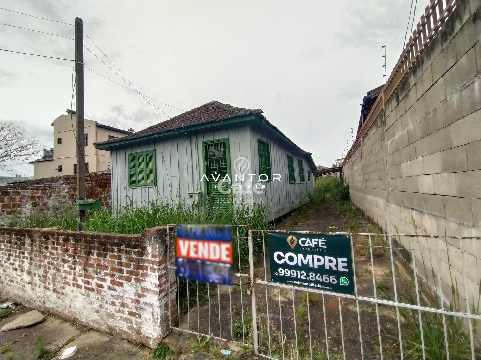 Fachada da casa com portas e janelas verdes — Terreno à venda em Duque de Caxias, Santa Maria/RS