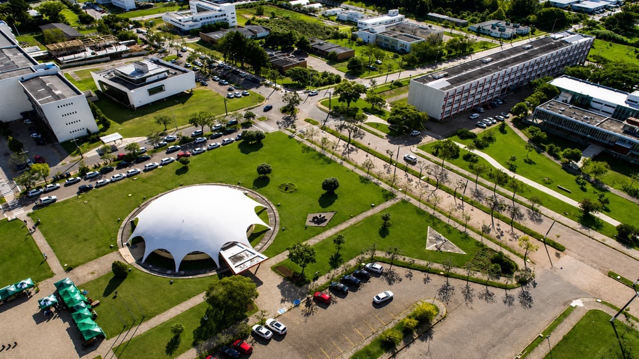 Vista aérea do campus da UFSM em Camobi, Santa Maria, com áreas verdes e o domo do Centro de Convivência