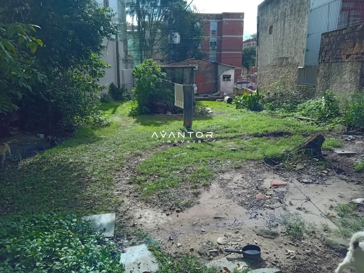 Terreno com vegetação e construções ao fundo — Terreno à venda em Nossa Senhora de Fátima, Santa Maria/RS