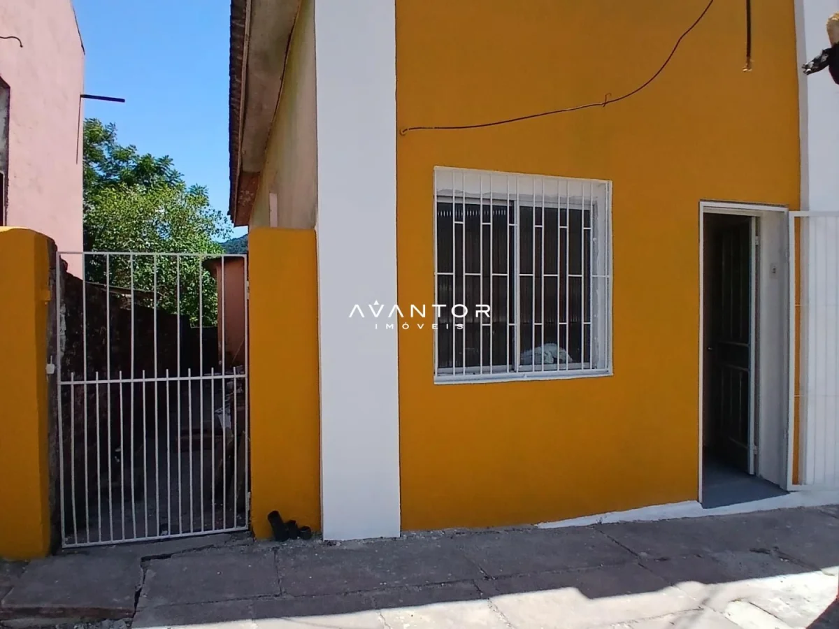 Fachada da casa com parede amarela — Casa com 2 quartos para alugar em Centro, Santa Maria/RS