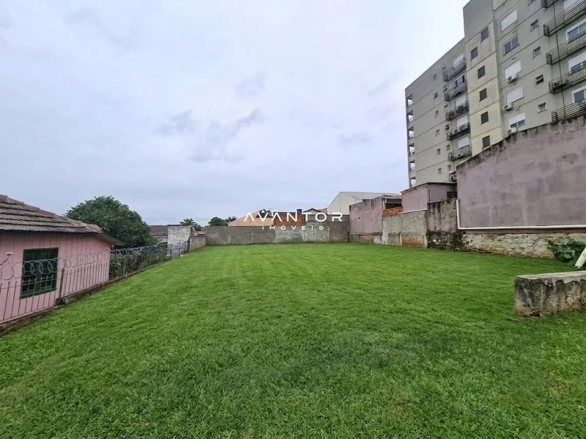 Terreno com grama e edifício ao fundo — Terreno à venda em Nossa Senhora Medianeira, Santa Maria/RS