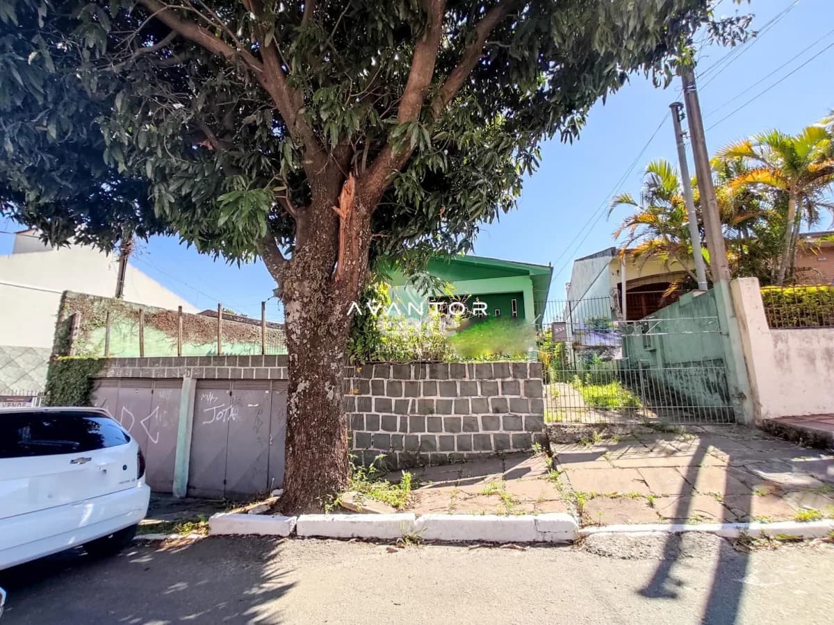 Fachada da casa com portão e árvore — Terreno à venda em Nossa Senhora do Rosário, Santa Maria/RS